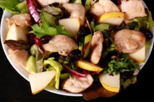 2 bowls of cranberry pear chicken salad and a bottle of cranberry-pear white balsamic vinaigrette.