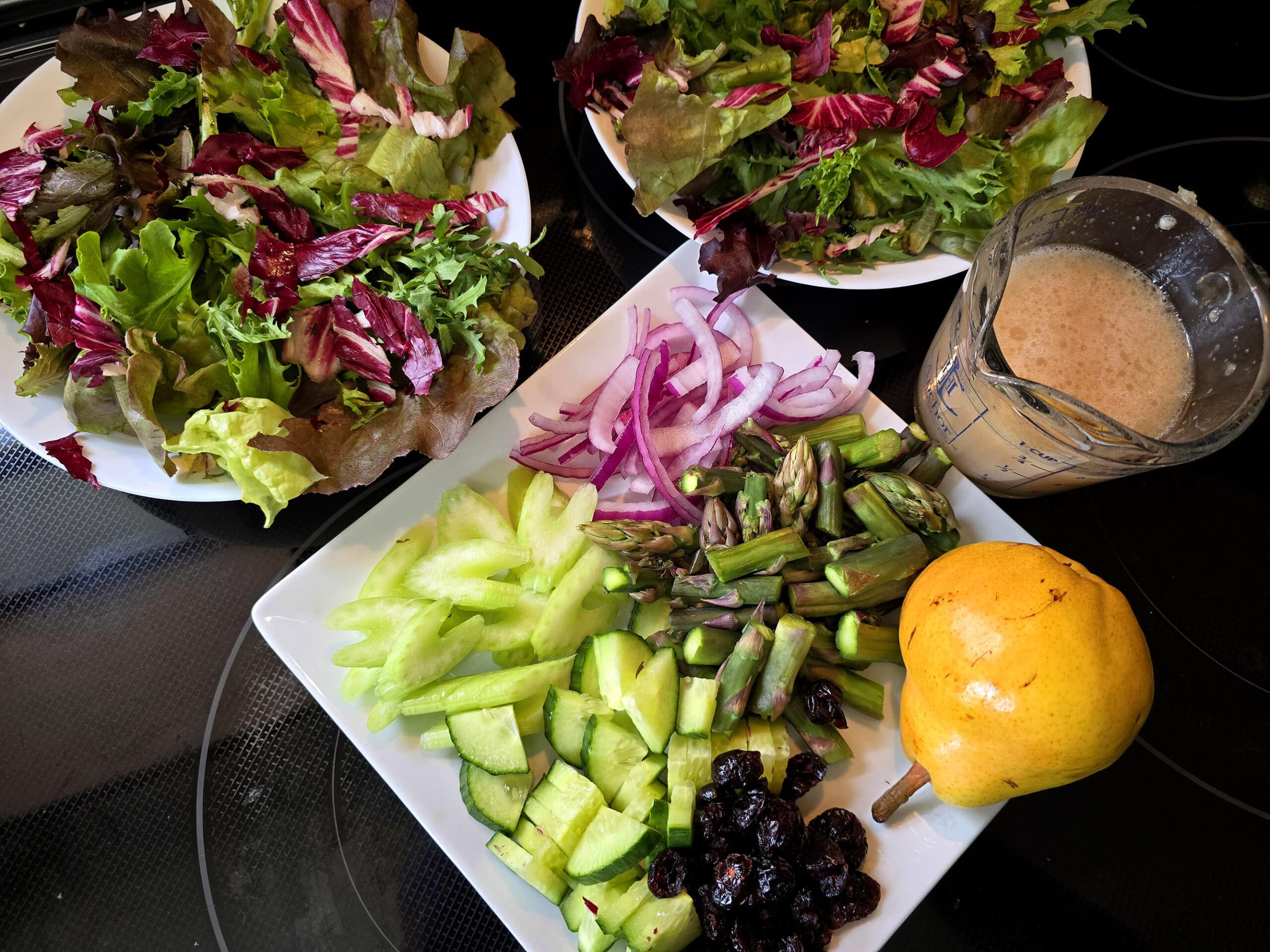 2 bowls of salad greens, and a plate of all the rest of the toppings.