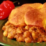 A serving of doubles casserole - a carribean inspired hotish with a spiced chickpea and potato filling, topped with spiced butter brushed biscuits.