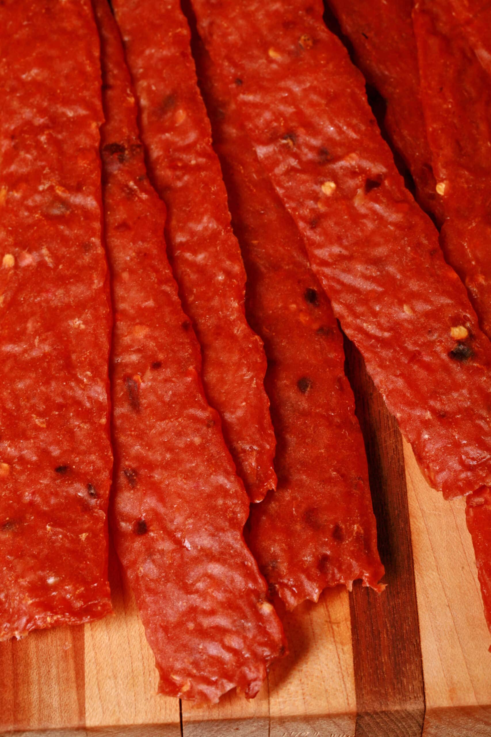 homemade orange chicken jerky on a cutting board.