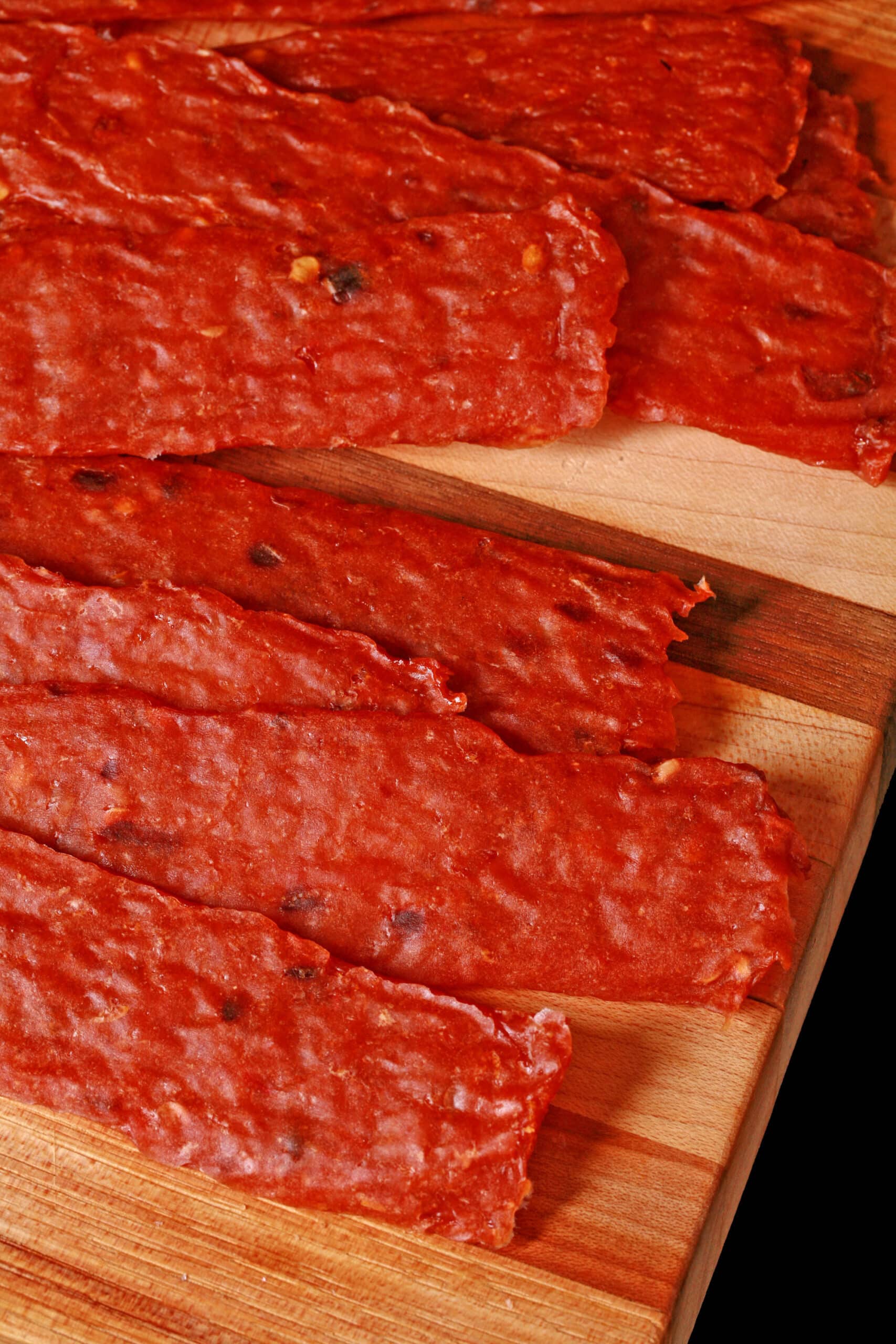 homemade orange chicken jerky on a cutting board.