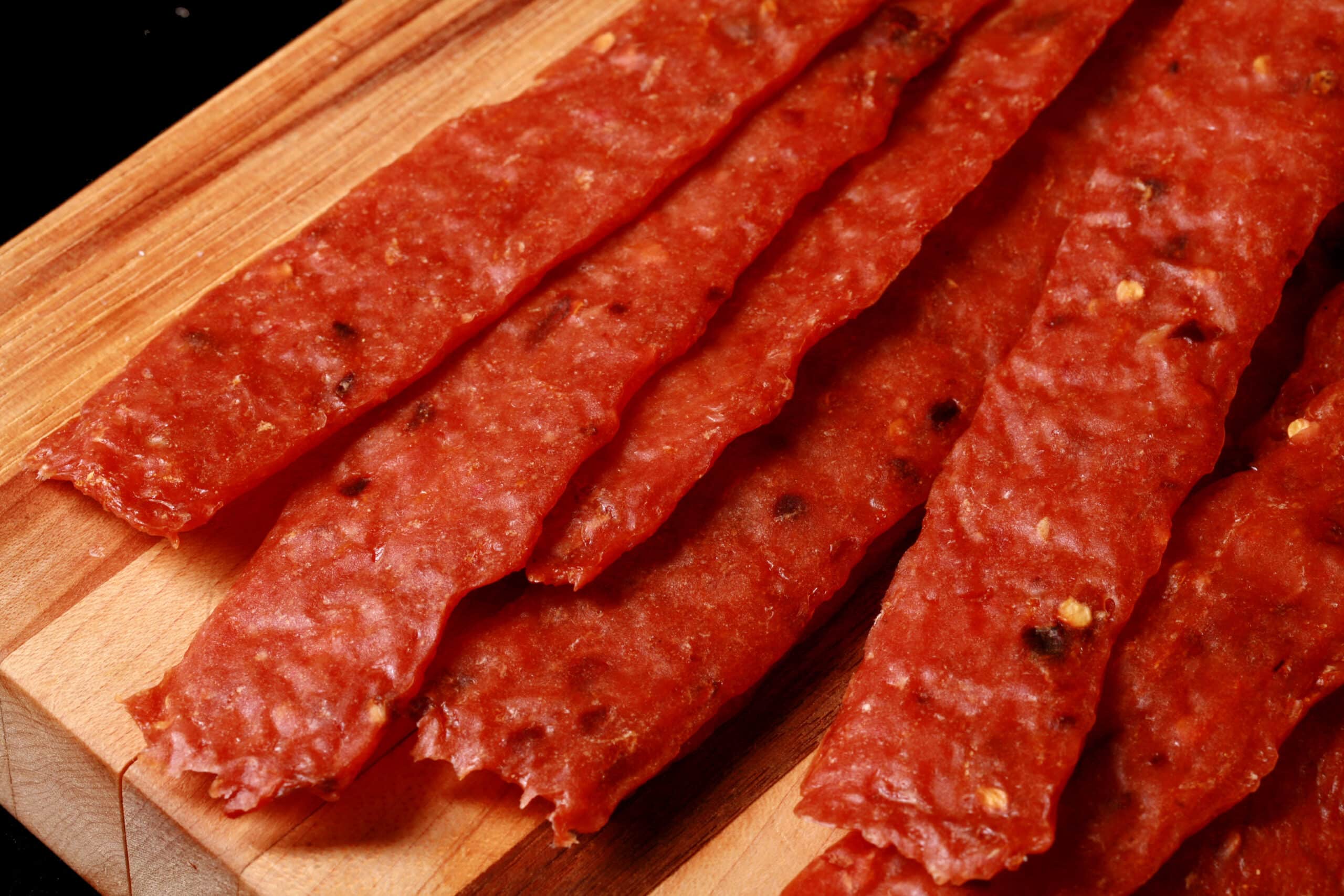 homemade orange chicken jerky on a cutting board.