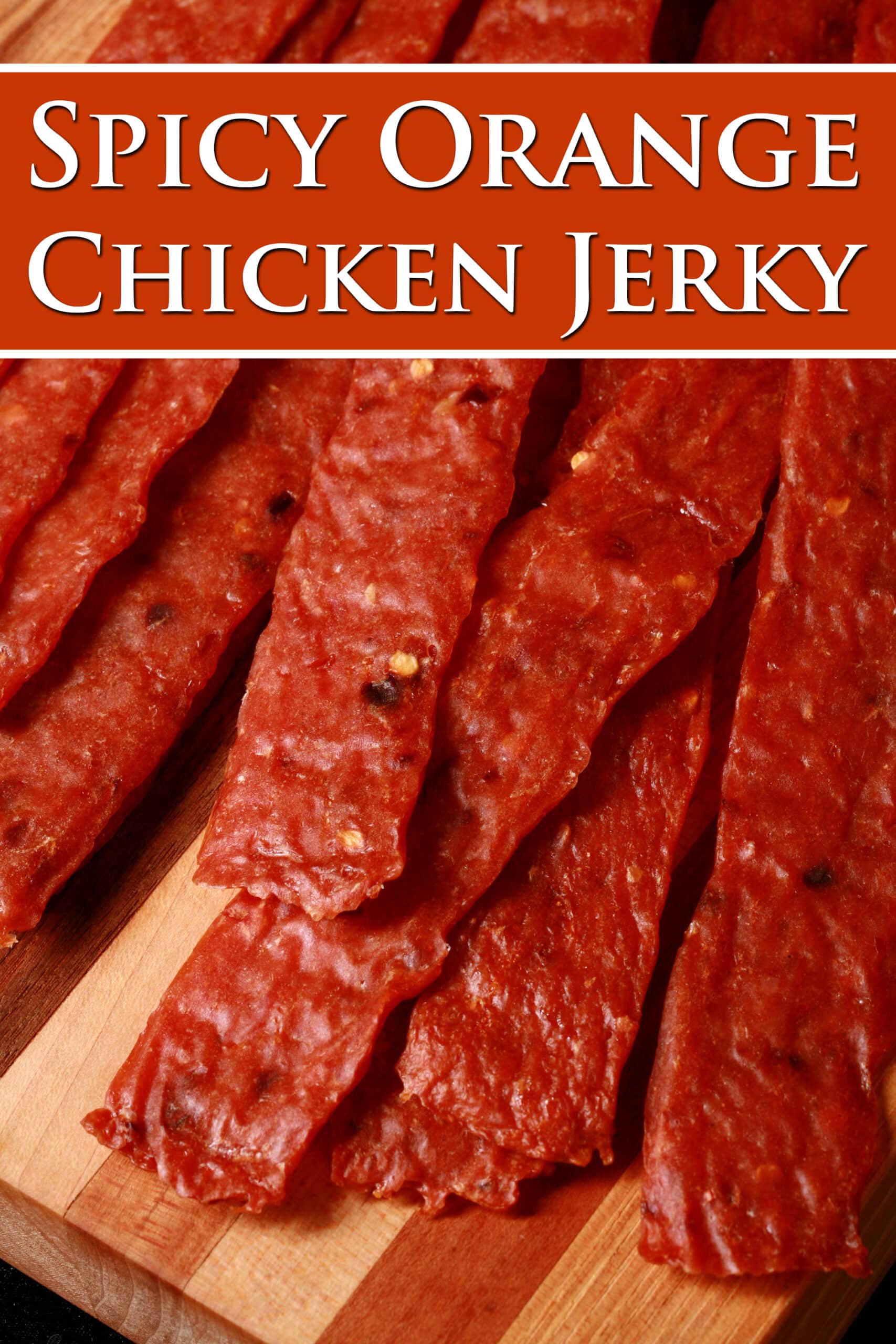 homemade orange chicken jerky on a cutting board. Overlaid text says spicy orange chicken jerky.