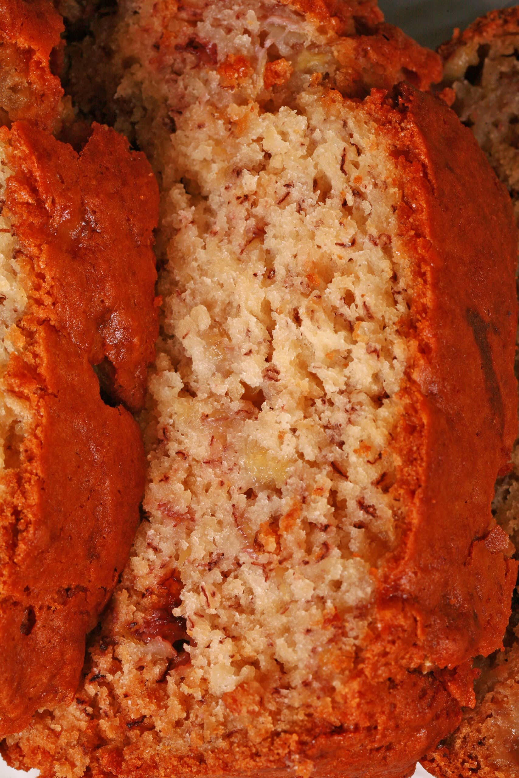 A sliced loaf of egg free banana bread on a white serving platter.