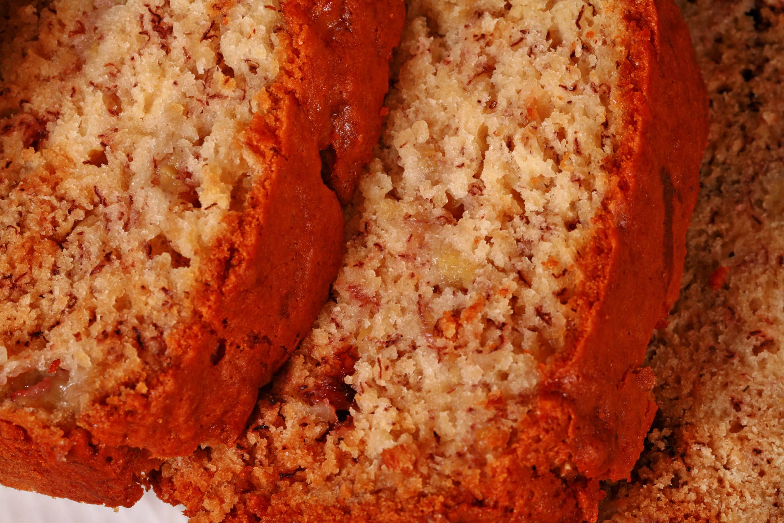 A sliced loaf of no egg banana bread on a white serving platter.