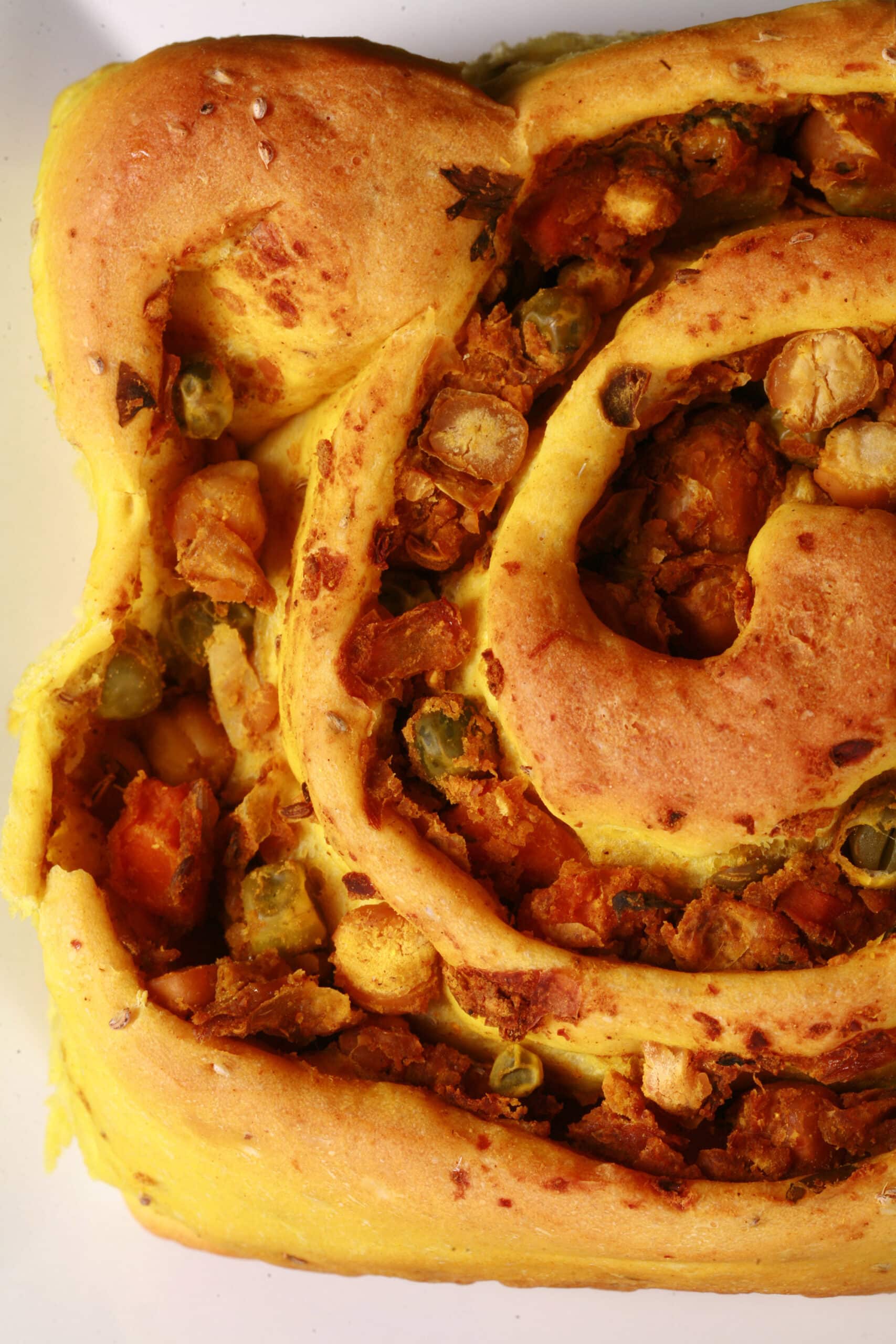 A Samosa Bun - A spiced dough rolled around a chickpea samosa filling, cinnamon roll style.