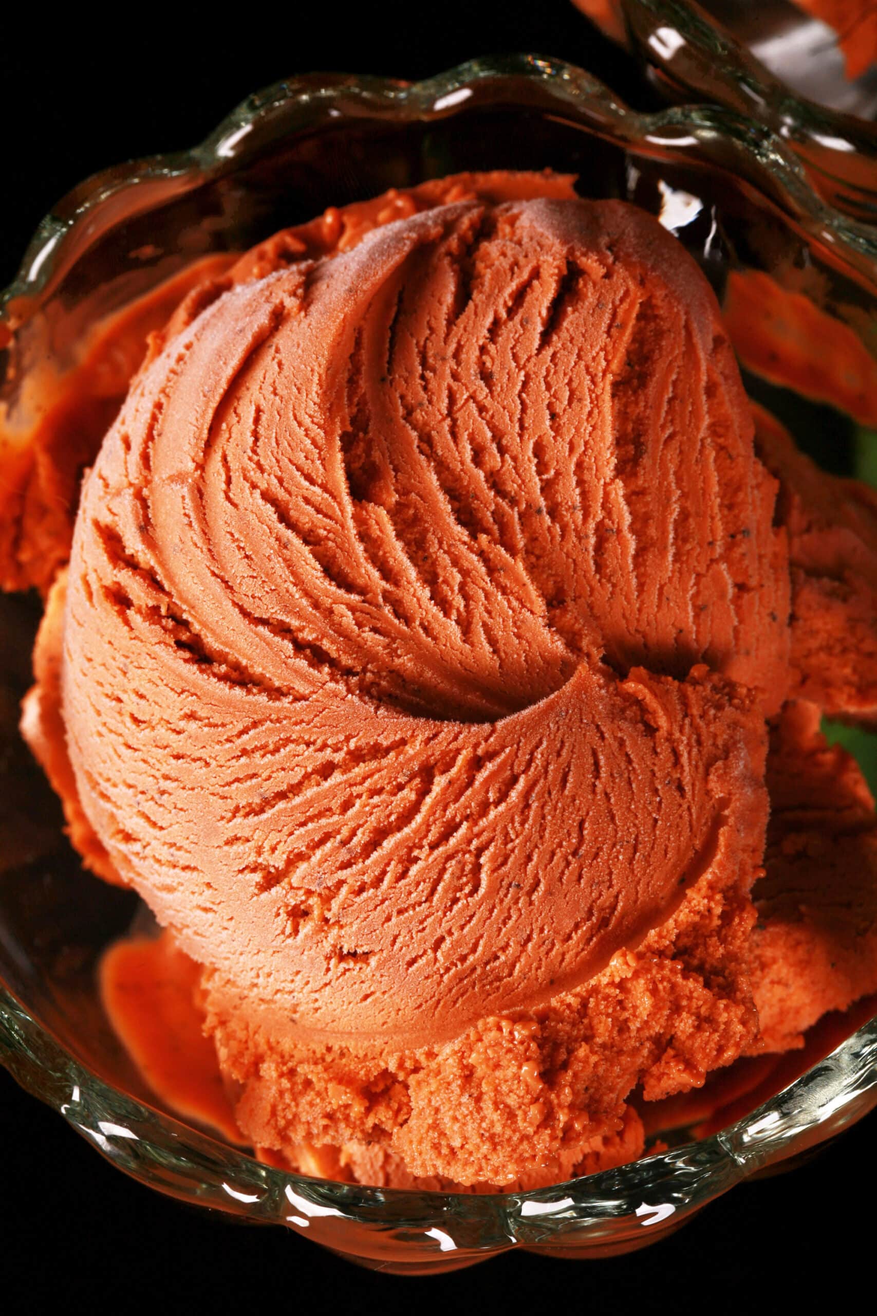 A bowl of Thai iced tea ice cream in a glass bowl.