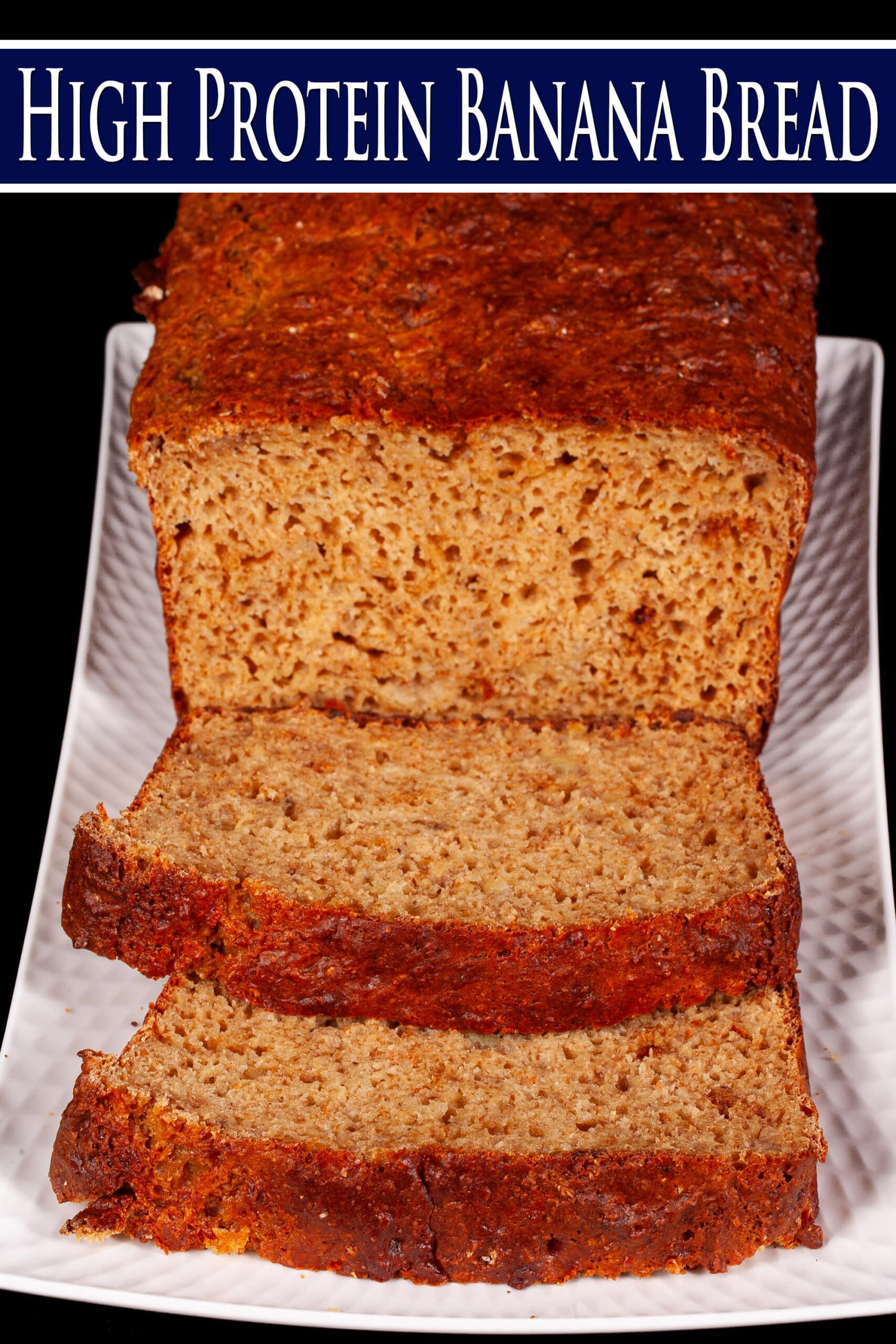 A sliced loaf of protein powder banana bread. Overlaid text says high protein banana bread.