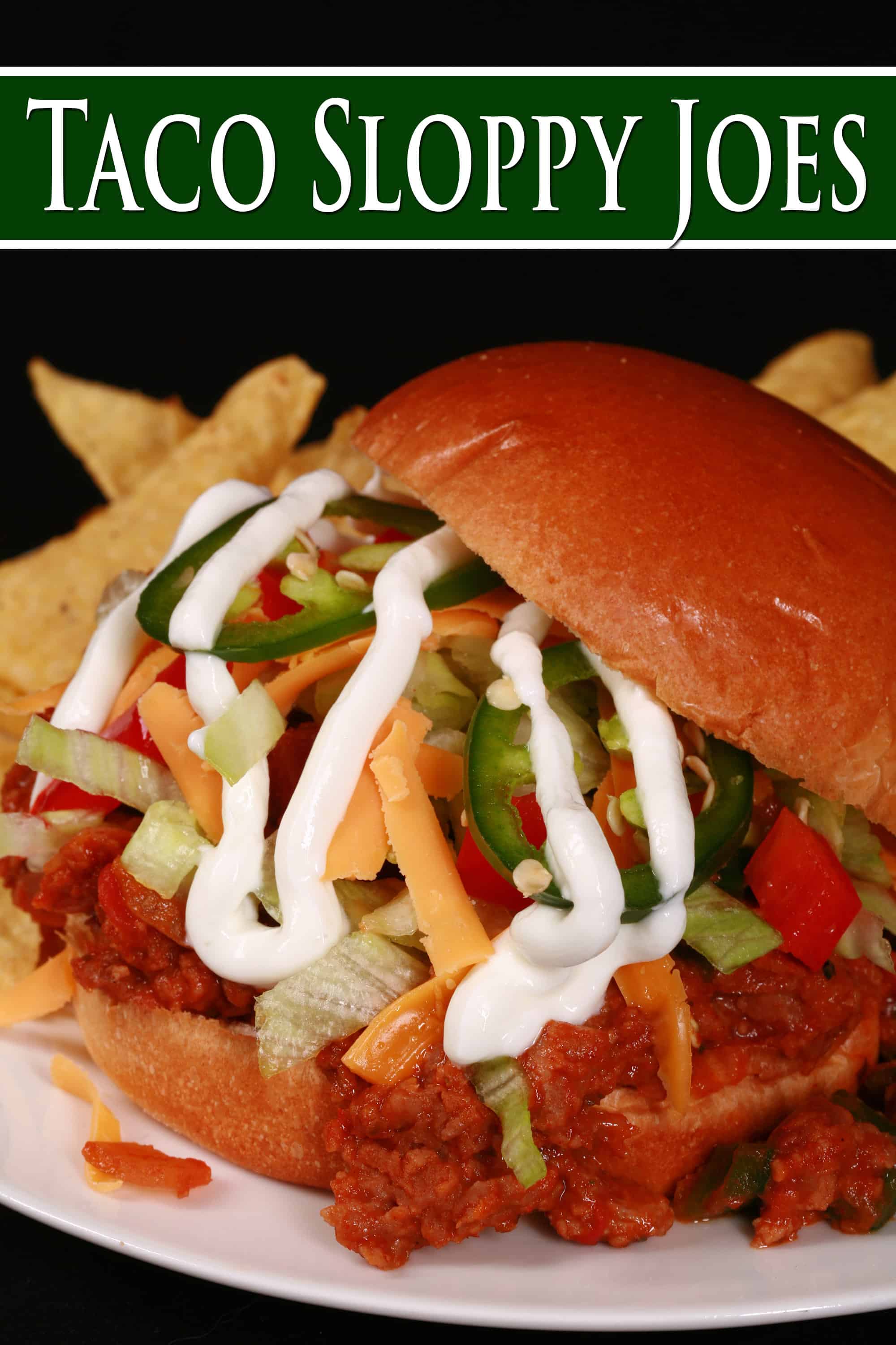 A Taco themed sloppy joe sandwich, with taco meat, lettuce, cheese, salsa, sour cream, and jalapeno slices, on a plate with tortilla chips. Overlaid text says taco sloppy joes.