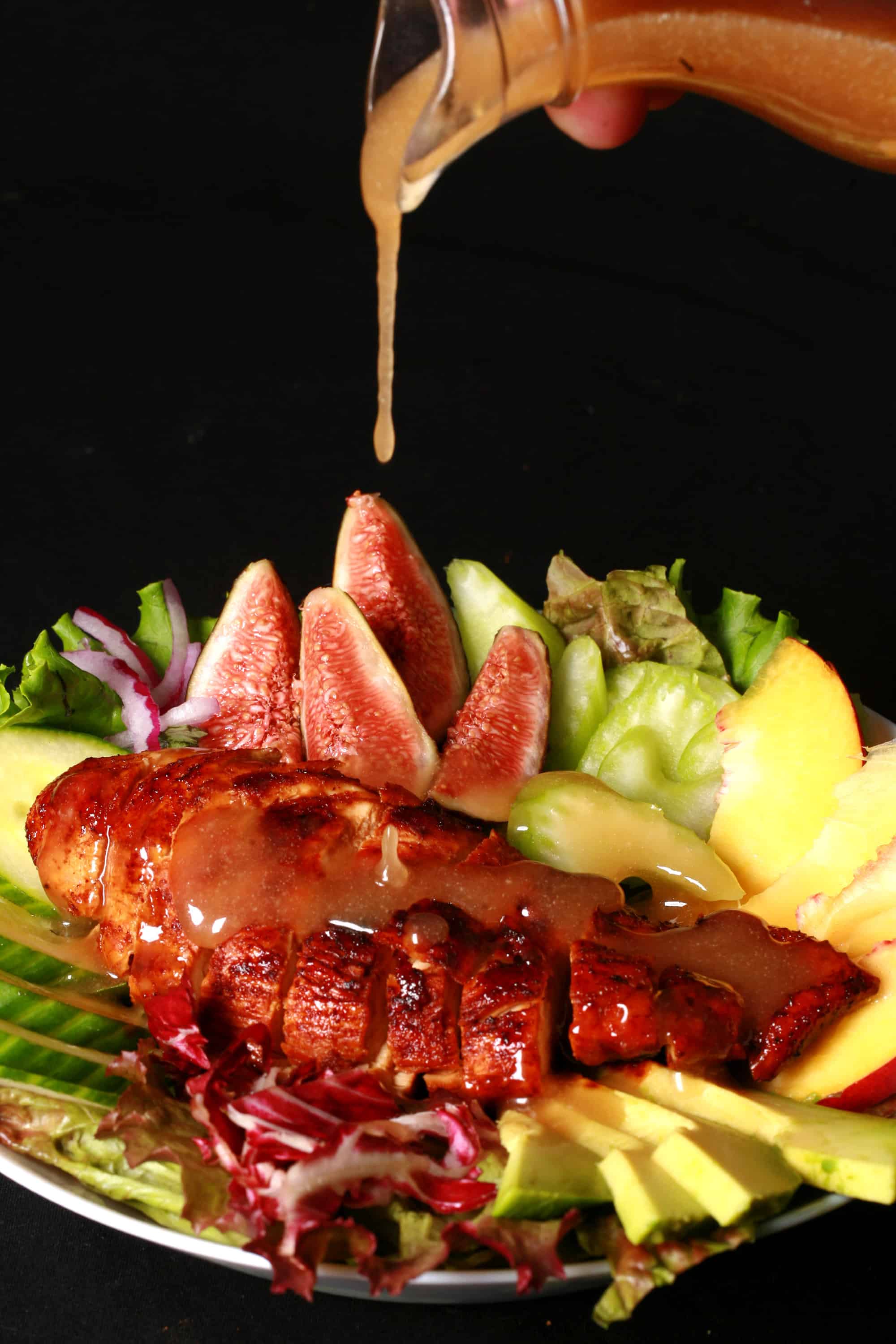 2 balsamic glazed chicken and peach salads, with peaches, figs, avocado, vegetables, and white peach balsamic vinegar glazed chicken breast.