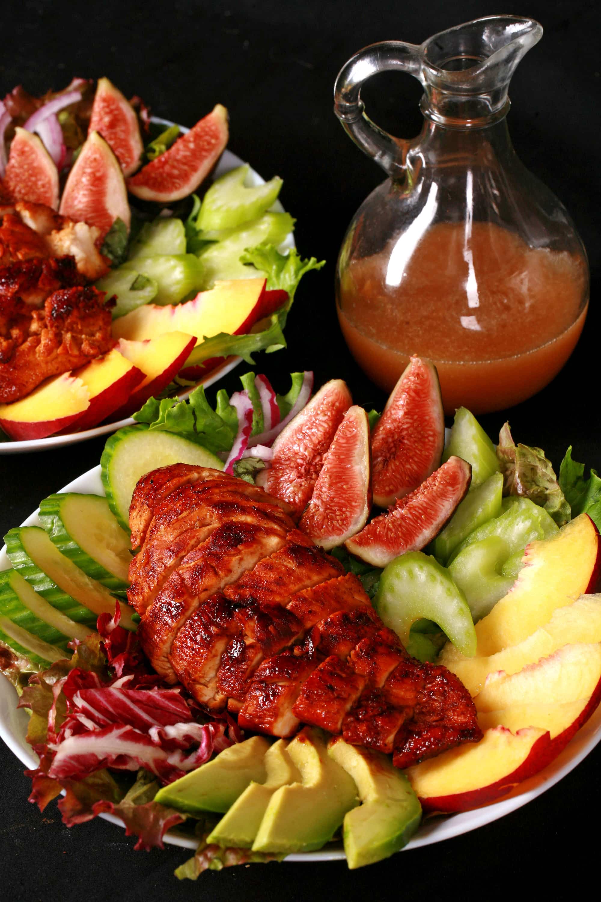 2 balsamic glazed chicken and peach salads, with peaches, figs, avocado, vegetables, and white peach balsamic vinegar glazed chicken breast.