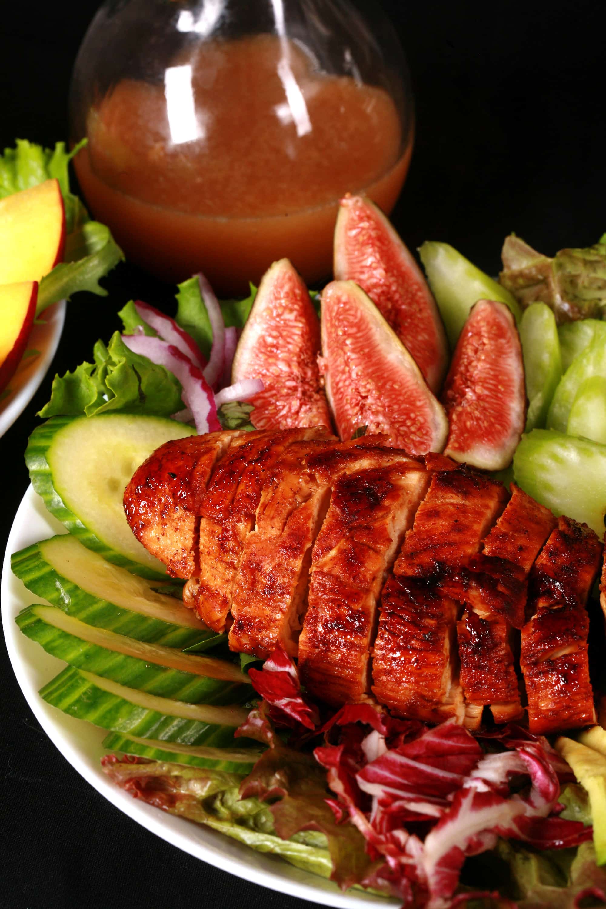 2 balsamic glazed chicken and peach salads, with peaches, figs, avocado, vegetables, and white peach balsamic vinegar glazed chicken breast.