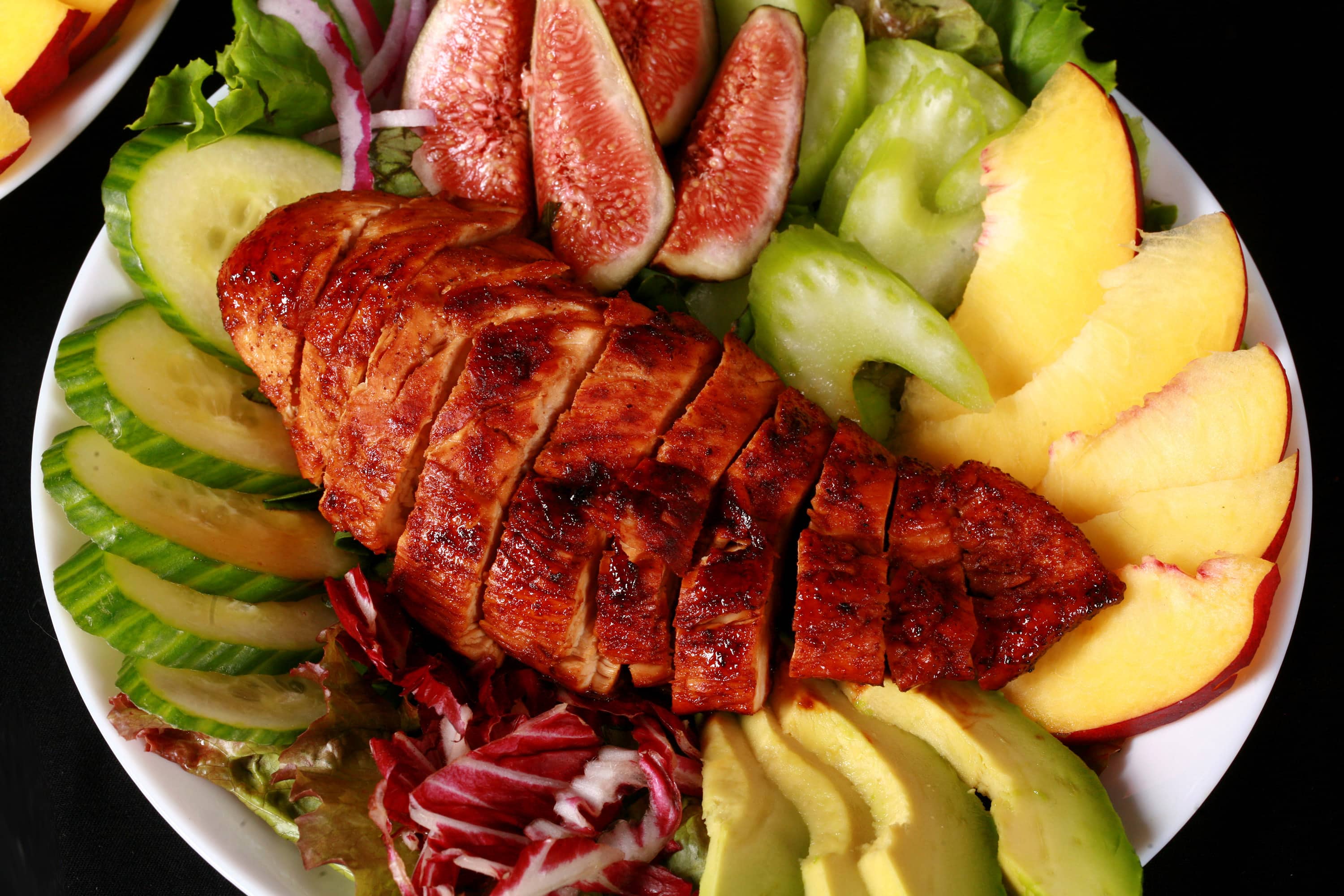 2 balsamic glazed chicken and peach salads, with peaches, figs, avocado, vegetables, and white peach balsamic vinegar glazed chicken breast.