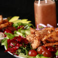 A balsamic chicken salad with red grapes and a bottle of homemade grape balsamic vinaigrette.