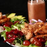 A balsamic chicken salad with red grapes and a bottle of homemade grape balsamic vinaigrette.
