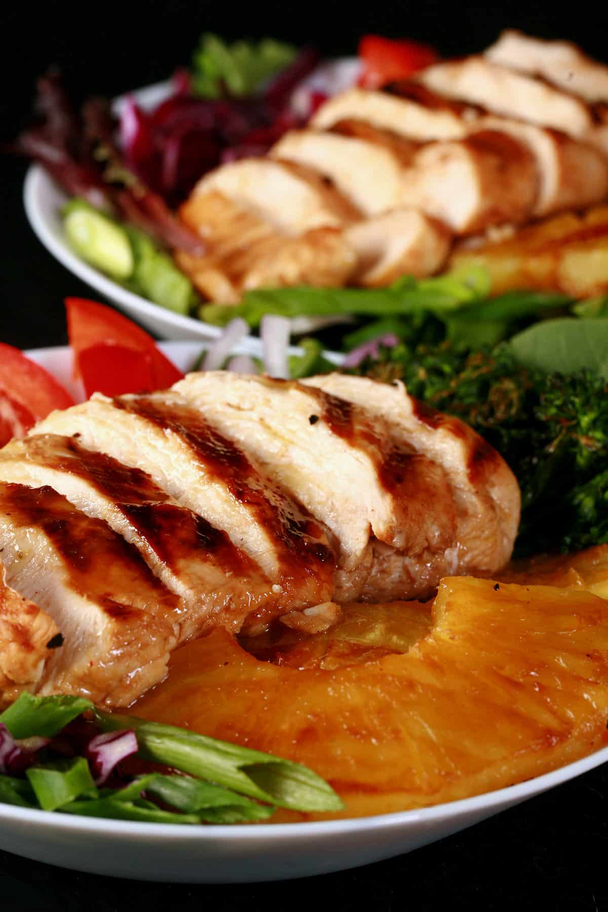 A grilled teriyaki chicken salad with fresh pineapple slices.